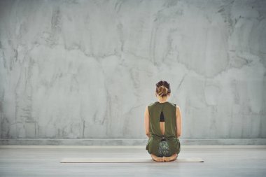 Thunderbolt yoga poz oturan sprtswear güzel Kafkas esmer Arka görünümü.