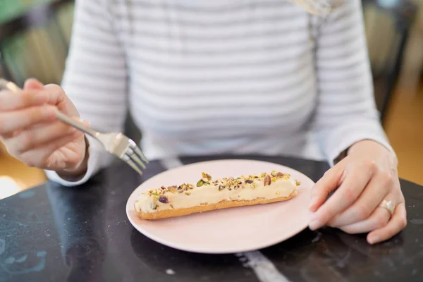 Mujer caucásica comiendo postre en pastelería . — Foto de Stock