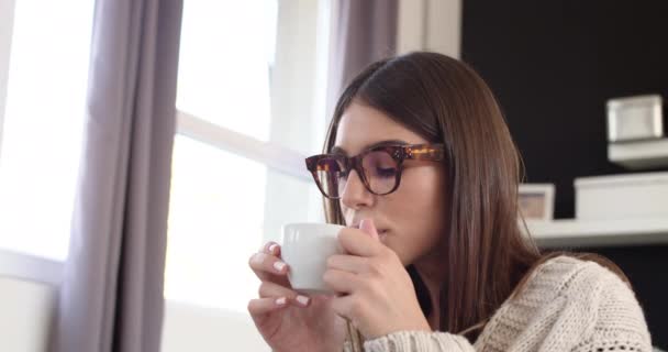 ベージュのセーターを着た白人女性がベッドに座り 新鮮な朝のコーヒーを飲む — ストック動画