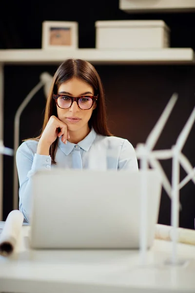 Resmi olarak odaklanmış güzel beyaz iş kadını ofiste otururken dizüstü bilgisayar kullanıyor. Sürdürülebilir geliştirme kavramı. — Stok fotoğraf