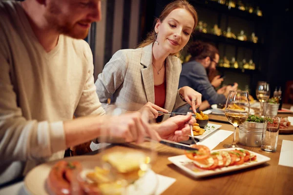 Group of friends sitting in retaurant and eating dinnner. — Stock Photo, Image