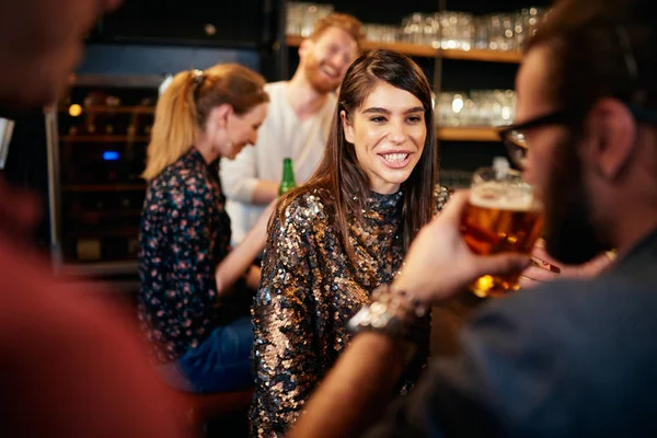 Un gruppo di amici che beve birra, chiacchiera e si diverte al pub. Notte fuori . — Foto Stock