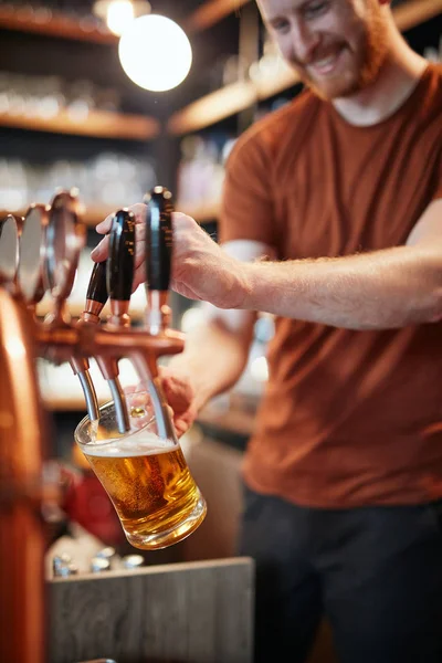 Schöner kaukasischer Barmann, der Bier einschenkt, während er in der Kneipe steht. se — Stockfoto