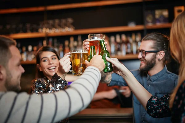 Amigos de pé no bar e brindar com cerveja . — Fotografia de Stock