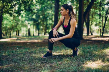 Beyaz tenli genç bayan koşucu koşmaktan dinleniyor ve dinleniyor..