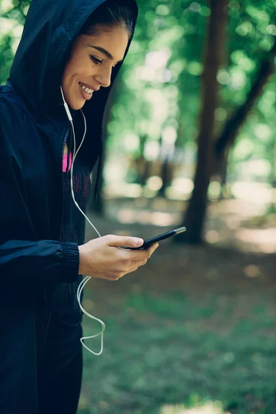 Genç Beyaz Kadın Kulaklık Takıyor Doğada Koşmak Için Müzik Seçiyor — Stok fotoğraf