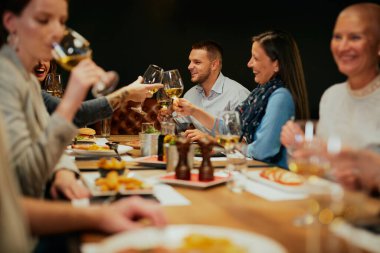 Bir grup arkadaş restoranda oturup beyaz şarapla kadeh kaldırıyorlar..