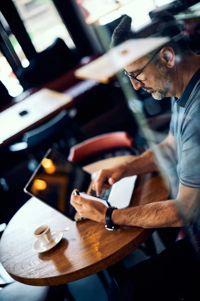 Hombre Maduro Sentado Cafetería Usando Teléfono Inteligente Hay Café Ordenador — Foto de Stock