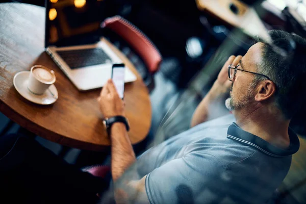 Hombre Maduro Sentado Cafetería Usando Teléfono Inteligente Hay Café Ordenador — Foto de Stock