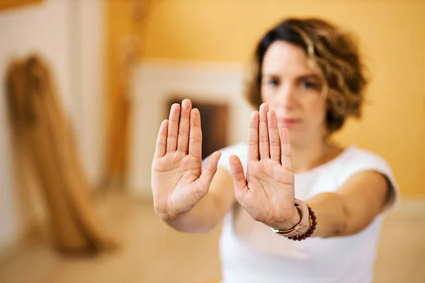 Closeup of woman holding hands outstretched and doing yoga.