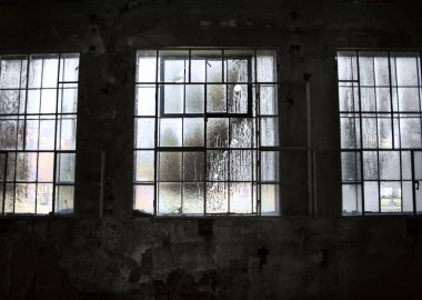 Eski, boş bir sanayi bölgesinde büyük kirli pencereler terk edilmiş bir fabrika, kasvetli parlak bir ışık