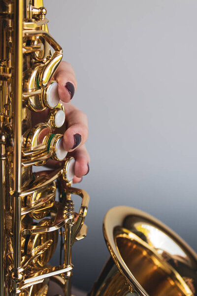 Saxophone girl player hands. Saxophonist playing jazz music. Alto sax