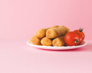 Pembe arka planda mozarella peynirli çubuklar ve domates tabağı, menü seti. Yakın plan.