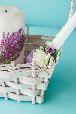 Parlak güzel çiçekleri olan beyaz düğün mumları, kopya alanı olan mavi arka planda izole edilmiş..