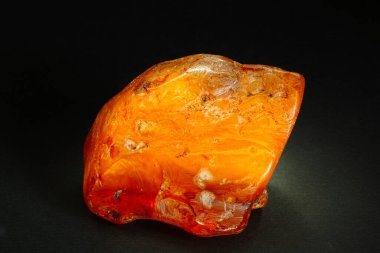Amber mı? Siyah arka planda büyük, şeffaf bir sarı kehribar parçası. Fosilleşmiş fosil reçinesi. Aynasız. Güneş taşı. Doğal mineral. Mücevher ve kuyumcular için malzeme. Parlatılmış antik kristal. Kehribar reçine desenlerindeki sonuçlar