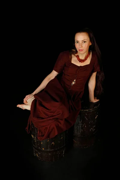 Model in a vintage vintage dress on a black background. Historical costume. Reconstruction of the 15th century. Renaissance painting with a girl and amber beads. Cosplay. A scene from medieval life. Amber beads. Portrait of a beautiful young woman