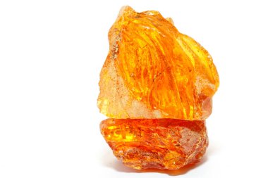 Beyaz arka planda şeffaf kehribar rengi bir parça. Aynasız. Tropik ağaçların fosil reçinesi. Güneş taşı. Mineral. Mücevherler için malzeme. Renkli kristal. Kehribardaki sonuçlar