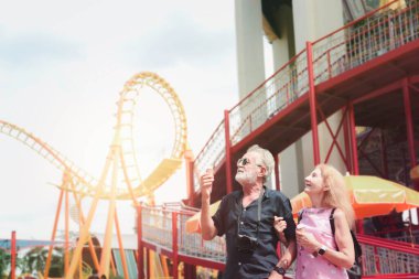 Yaşlı çiftler yaz tatilinde lunaparkta vakit geçiriyorlar, yaşlılar lunaparkta takılıyor ve eğleniyorlar..