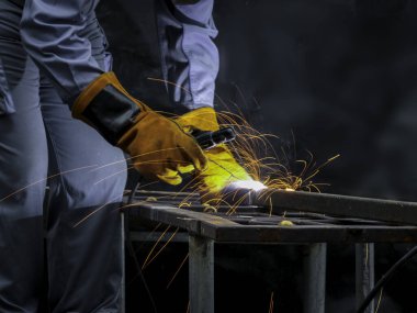 Fabrikada güvenlik maskesi, kask ve metal kaynaklama gözlüğü takan endüstriyel işçiler. Fabrikada çalışan endüstriyel makine mühendisi çelik kaynak yapısında.