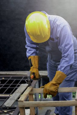 Güvenlik ekipmanı takan işçiler, tamir ve bakım için çekiç tutan marangozlar, tahta mobilyaları tamir etmek için çivi çakan çekiçli adamlar.