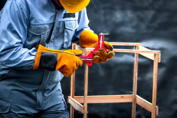 安全装置を身に着けている労働者 修理やメンテナンスのための機械工具で大工仕事 いくつかの木製の家具を修正するために働く男 — ストック写真