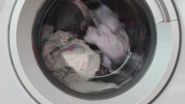 Çamaşır makinesi içinde dönen giysilerle çalışıyor, çamaşır makinesiyle bez temizleme işlemi, çamaşır konsepti