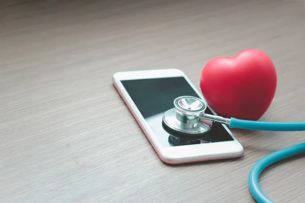 Doctor online concept, red heart with stethoscope and  smartphone for online consultation with patient, online medical communication on virtual interface, virtual hospital