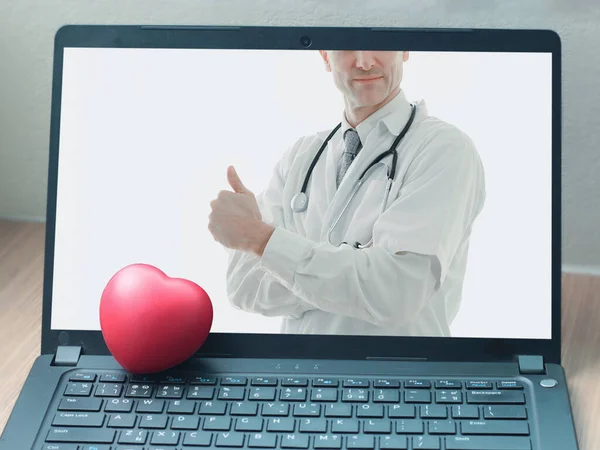 Doctor online concept, red heart and a doctor with stethoscope on computer laptop screen for online consultation with patient, online medical communication on virtual interface, virtual hospital