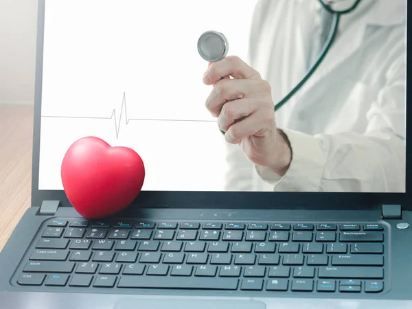 Doctor online concept, red heart and a doctor with stethoscope on computer laptop screen for online consultation with patient, online medical communication on virtual interface, virtual hospital