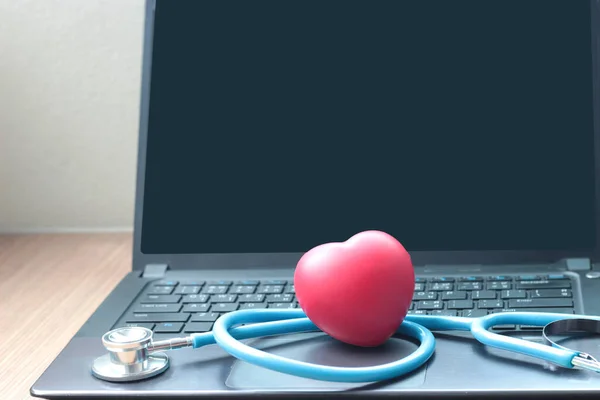 Doctor online concept, red heart with stethoscope and a doctor on computer laptop screen for online consultation with patient, online medical communication on virtual interface, virtual hospital