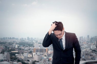 Gökdelen şehri açıklarında takım elbiseli genç Asyalı işadamı, stresli bir adam kafasını eline koyar, işini düşünür, hayal kırıklığına uğramış ya da yorgun hisseder..