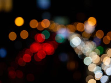 Bokeh gece lambası arkaplanı soyut, bulanık ışıklar yoldaki arabaların izleri, geceleri sokaktaki trafiğin dağıtılması.