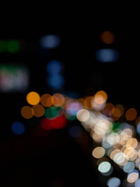 Bokeh gece lambası arkaplanı soyut, bulanık ışıklar yoldaki arabaların izleri, geceleri sokaktaki trafiğin dağıtılması.