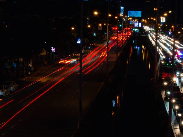 Geceleyin Sokakta Uzun Işık Izleri Yol Üzerindeki Arabaların Bulanık Izleriyle — Stok fotoğraf