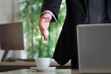 Takım elbiseli bir işadamı, telif alanı ile el sıkışmaya hazır bir adam, iş yerinde anlaşma yapmaya hazır bir adam.