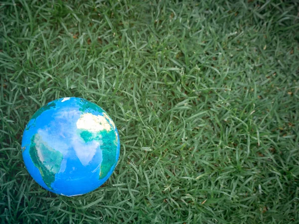 Earth on on green grass, save the world, love and protect our planet, and environmental  friendly concept