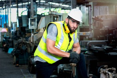 Sanayi mühendisi portresi, kask ve gözlük takıyor fabrika fabrikasında duruyor.