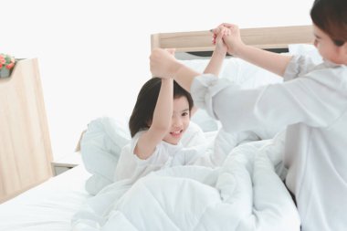 Mutlu aile yatak odasında eğleniyor. Anne ve kızı birlikte vakit geçiriyorlar, küçük kız annesiyle yatakta oynuyor, anne ve babası ve çocuğu evde iyi bir hafızaya sahip.