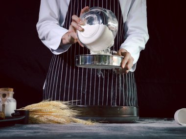 Fırıncı bir kaseye un karıştırıyor, ekmek hamuru hazırlıyor, hamuru yoğuruyor. Un sıçramalı eller, ev yapımı fırın konsepti.