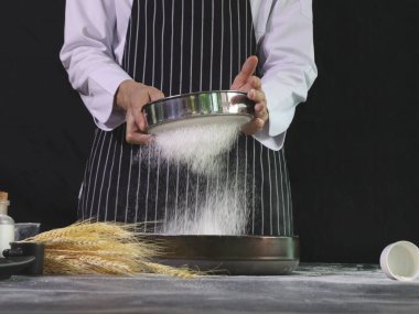 Fırıncı bir kaseye un karıştırıyor, ekmek hamuru hazırlıyor, hamuru yoğuruyor. Un sıçramalı eller, ev yapımı fırın konsepti.