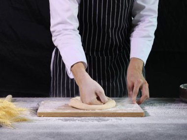 Ellerin ekmek hamuru hazırlıyor, hamuru yoğuruyor. Un sıçramalı eller, ev yapımı fırın konsepti.