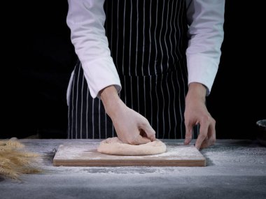 Ellerin ekmek hamuru hazırlıyor, hamuru yoğuruyor. Un sıçramalı eller, ev yapımı fırın konsepti.