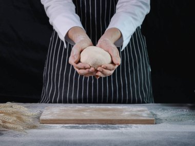 Ellerin ekmek hamuru hazırlıyor, hamuru yoğuruyor. Un sıçramalı eller, ev yapımı fırın konsepti.