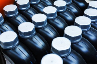 Motor yağlı bir sürü plastik kaplar. Petrol ürünlerinin şişelenmesi için konteyner.