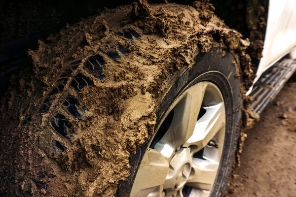 Dirty car wheel after an extreme ride. Traveling by SUV to places without asphalt. Close-up