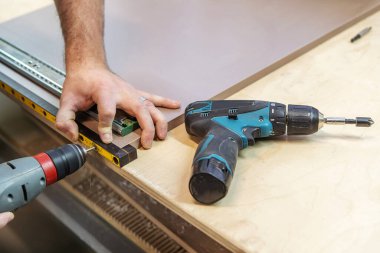 Bir marangoz bir mobilya parçası yapar. Tahta bir panelde delik açmak. Yakın plan. Seçici odak