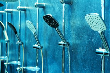 Duş başlıkları bir tesisat dükkanının duvarına asılmış. Küvetler için modern ekipman ticareti