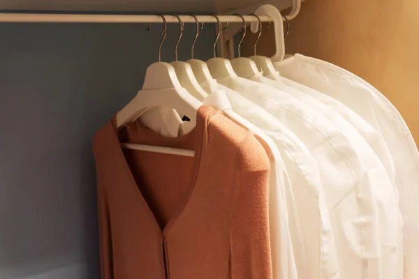 Old clothes in a closet on hangers. Old-fashioned things in the wardrobe.