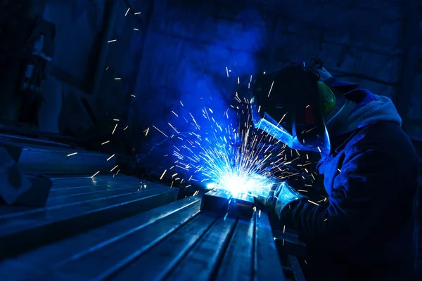 The welder works with a metal profile. Assembly of metal structures in industrial production