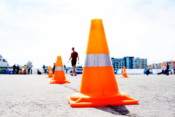 Orange cones on a city street. Limit traffic on a stretch of road. Unrecognizable faces. Genre photo